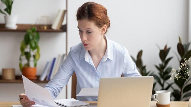 Vrouw achter laptop bekijkt cijfers